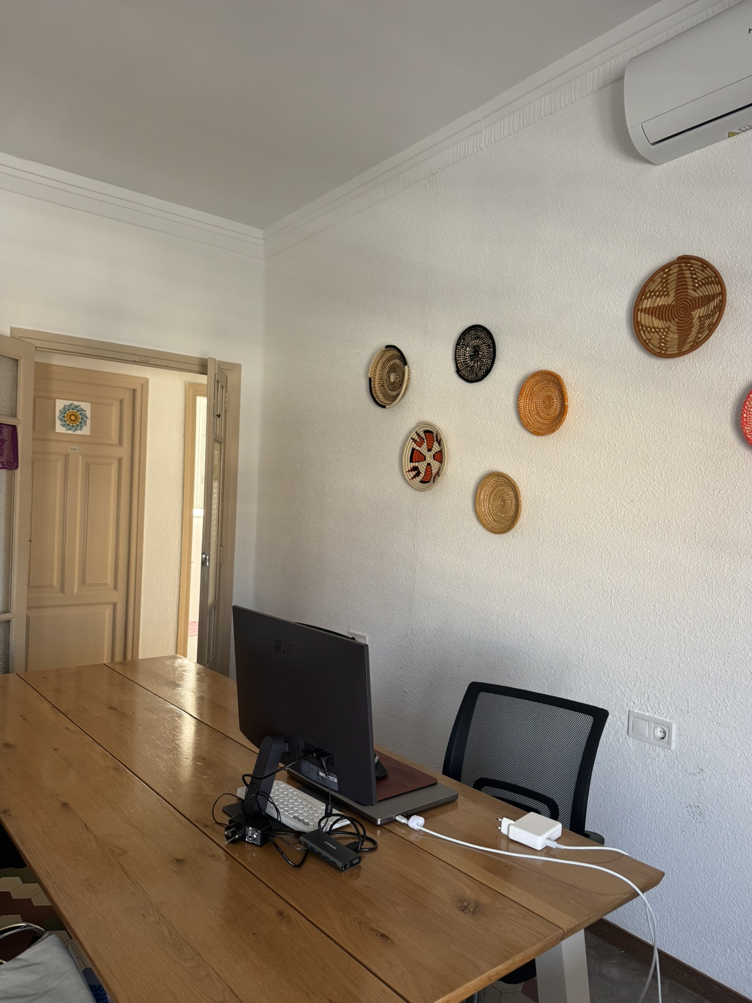 Coworking space at Folks Coliving Valencia - long wooden table, monitor and ergonomic chairs