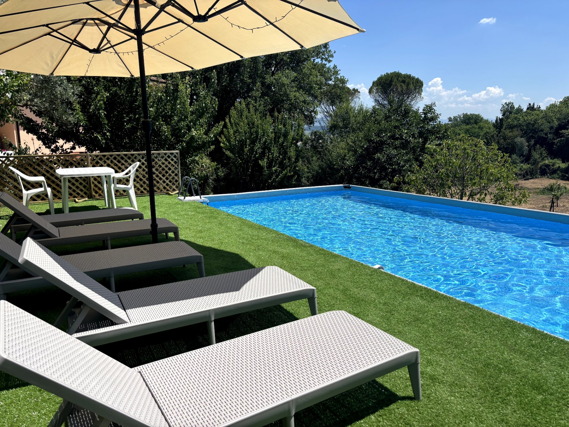 Pool and sun loungers overlooking the Lazio countryside at Nesting Away coliving in Orte, Italy
