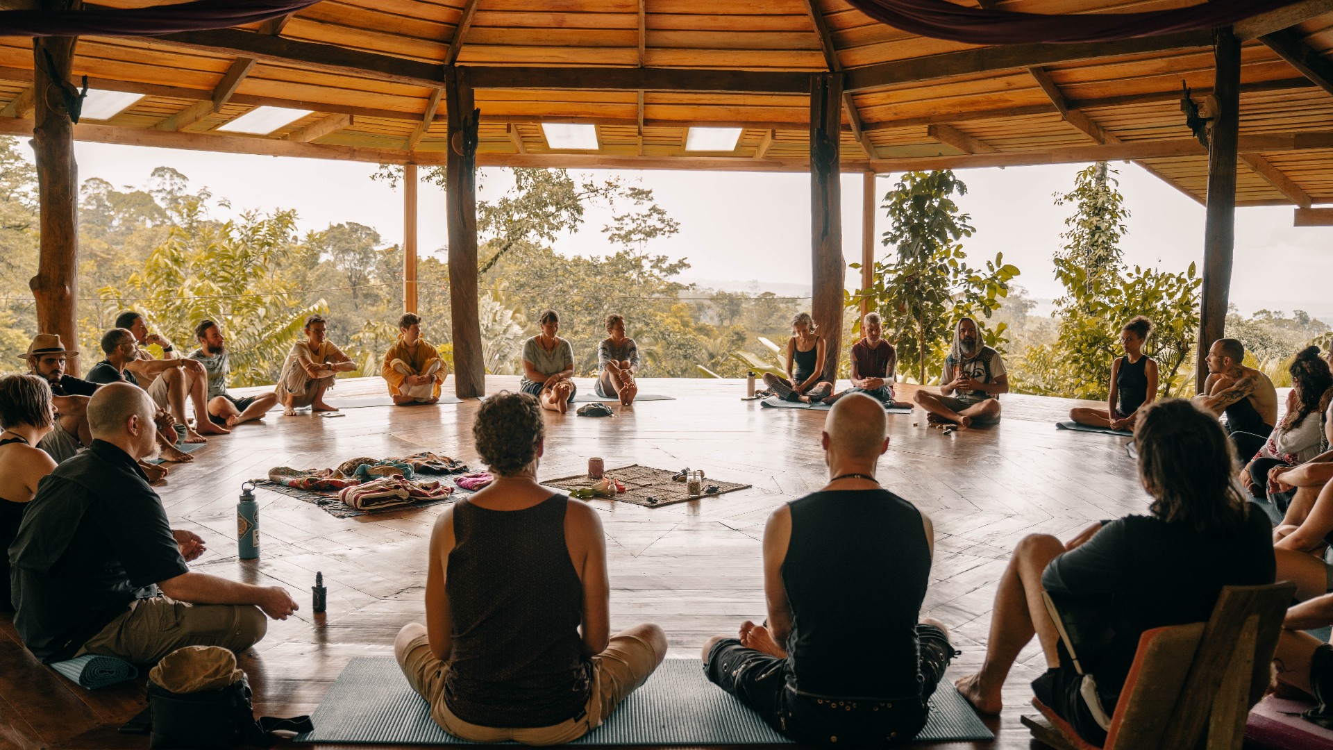 Residents sitting in a circle in the open air movement space at Protopia Community, Costa Rica